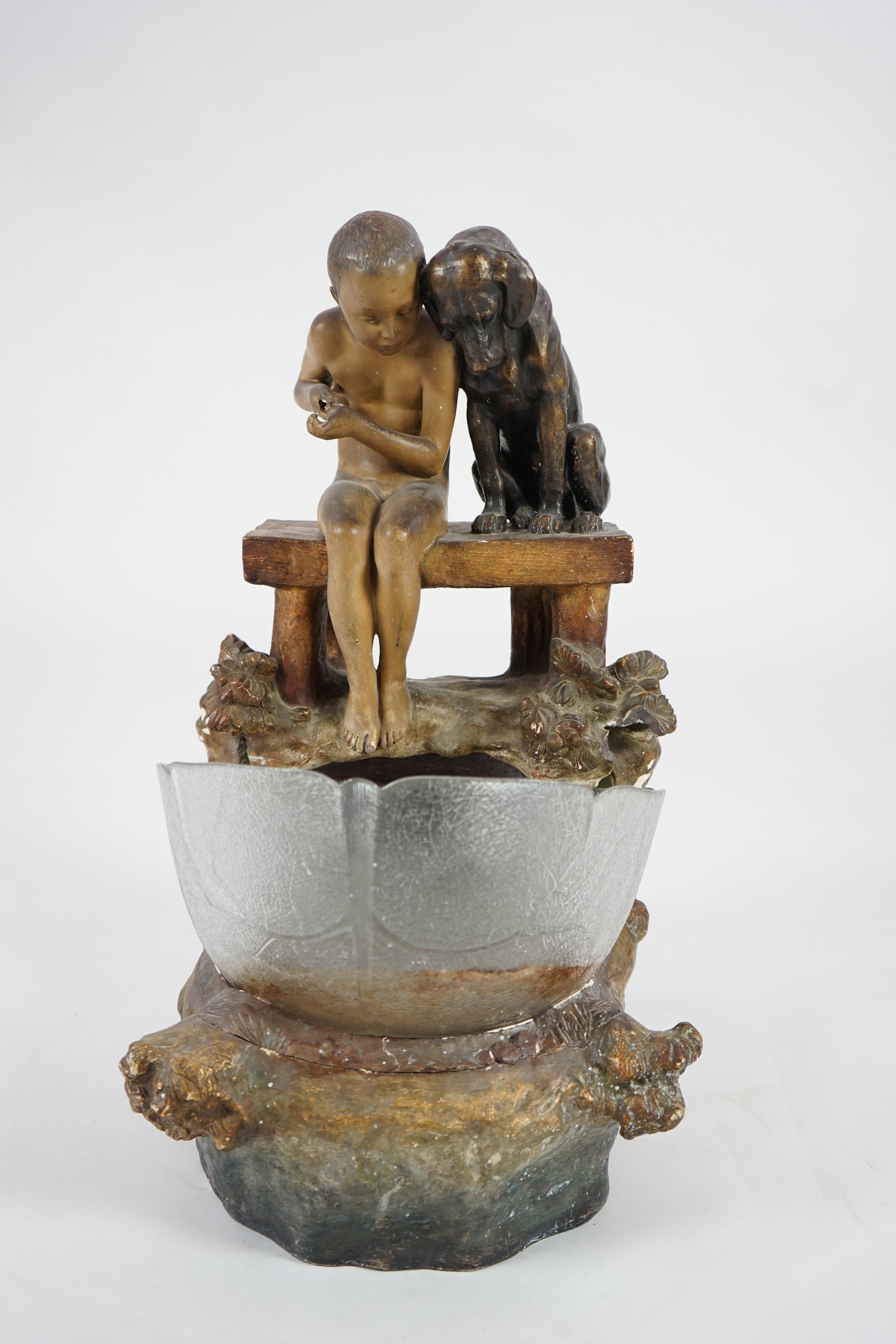 A Goldscheider group of a boy and a dog looking into a pool. Condition - fair, glass bowl not original